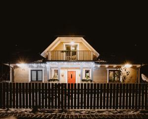 una casa con un balcone sopra di essa di notte di PUSZCZYKOWO siedlisko&spa a Białowieża