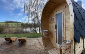 une cabine en bois avec une terrasse et une porte dans l'établissement Yary Yurt, à Všeruby