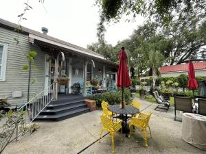 Bywater Home, Parking and Pet Friendly Retreat في نيو أورلينز: فناء مع طاولة مع كراسي ومظلة