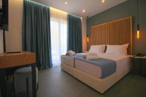 a bedroom with a large bed with a desk and a television at Blue Eye Hotel in Ksamil