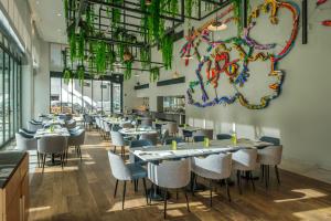 - un restaurant avec des tables et des chaises dans une salle dans l'établissement Martinhal Lisbon Oriente, à Lisbonne