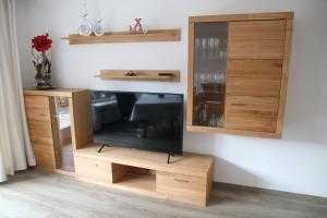 ein Entertainment-Center mit einem TV und Holzschränken in der Unterkunft Alpen - Apartments in Garmisch-Partenkirchen