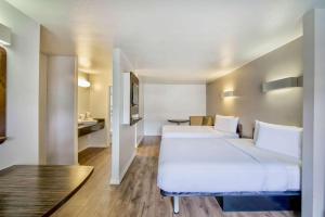 a hotel room with two beds and a table at Studio 6-San Antonio, TX - Airport in San Antonio