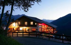 uma casa com luzes acesas nas montanhas à noite em Hotel Bellwald em Bellwald