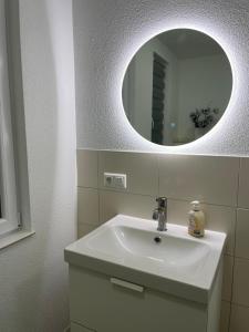 y baño con lavabo blanco y espejo. en Tolle Ferienwohnung im Herzen von Thüringen, en Eisenach