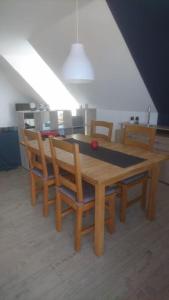 mesa de comedor de madera con sillas y mesa en Schleiblick im Andersenhof, en Kappeln