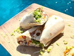 un burrito cortado a la mitad en una tabla de cortar en Gili Breeze Tropical Bungalows, en Gili Trawangan