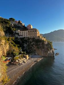 un bâtiment sur le côté d'une montagne à côté de l'eau dans l'établissement Casa Angelica, à Ravello