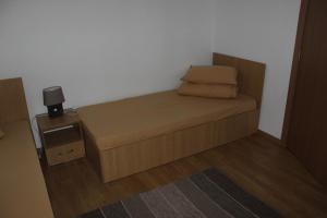 a small bedroom with a bed and a night stand at Pensiunea Martinel in Timisu de Sus