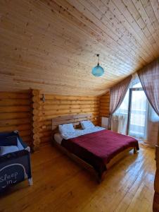 - une chambre avec un lit dans une pièce en bois dans l'établissement LOG HOUSE, à Bakuriani