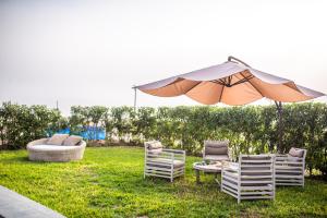 einen Regenschirm, zwei Stühle und einen Tisch mit Sonnenschirm in der Unterkunft Topara Hotel Boutique in San Vicente de Cañete