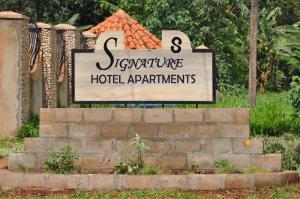 un panneau pour un hôtel avec un panneau pour un bâtiment dans l'établissement Signature Hotel Apartments, à Jinja