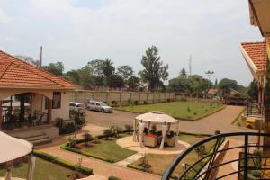 une maison avec un jardin et un kiosque dans une cour dans l'établissement Signature Hotel Apartments, à Jinja