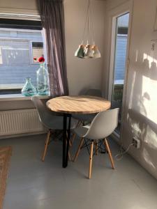 d'une salle à manger avec une table, des chaises et une fenêtre. dans l'établissement Houseboat apartment with water terrace, free parking, free bikes & fast wifi, à Amsterdam