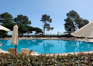 una gran piscina con sillas y sombrillas en PortoBay Falesia, en Albufeira