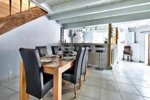 comedor con mesa de madera y sillas negras en Maison Saint-Thomas, en Cuiseaux