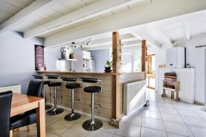 cocina con barra con taburetes en una habitación en Maison Saint-Thomas, en Cuiseaux