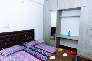 sypialnia z łóżkiem i dużym lustrem w obiekcie RVR Abode -Private Rooms w mieście Bengaluru