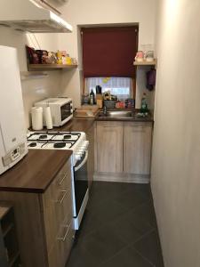 a small kitchen with a stove and a microwave at Pitypang Apartman in Gyula