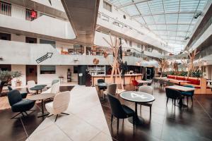 een restaurant met tafels en stoelen in een gebouw bij COWOOL Cergy in Cergy