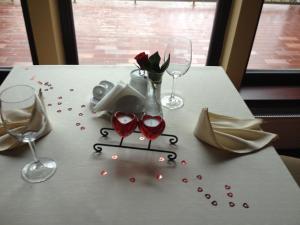 - une table avec deux verres à vin et des roses dans l'établissement Grafo Zubovo Hotel & SPA, à Bubiai