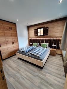 1 dormitorio con 1 cama grande y armarios de madera en DaHome Appartements, en Radstadt