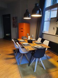 uma mesa de jantar com cadeiras brancas à volta em Loft mit privater Sauna em Heidelberg