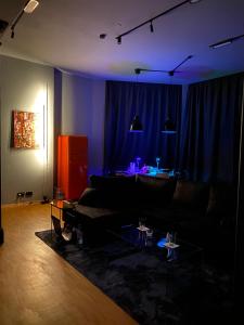 uma sala de estar com um sofá preto e uma cortina azul em Loft mit privater Sauna em Heidelberg