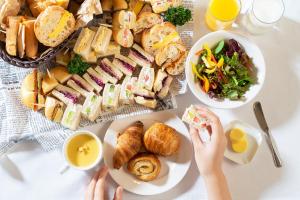 einen Tisch voller Essen mit Sandwiches und Salat in der Unterkunft Kobe Tor Road Hotel Sanraku in Kōbe