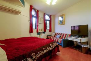 a bedroom with a red bed and a couch at Nikko Park Lodge Mountain Side in Nikko