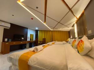 a bedroom with a large white bed with pillows at NGN Gran Hotel in Tuguegarao City