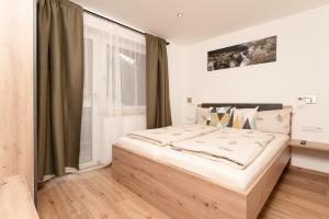 a bedroom with a large bed with a window at Bergnest Oetztal - Appartements in Umhausen