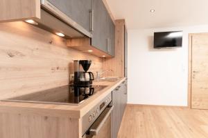 a kitchen with wooden cabinets and a counter top at Bergnest Oetztal - Appartements in Umhausen