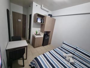 a bedroom with a bed and a desk and a sink at Macks Awesome Place 204 NetflixFastWifi in Manila