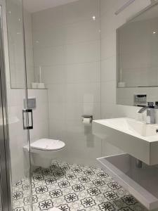 bagno bianco con servizi igienici e lavandino di Park Hotel Kur & Spa a Świeradów-Zdrój