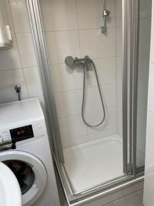 La salle de bains est pourvue d'une douche et d'un lave-linge. dans l'établissement City Appartement 4600, à Wels