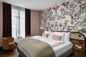 - une chambre avec un grand lit et du papier peint floral dans l'établissement Boutique Hotel Seidenhof, à Zurich