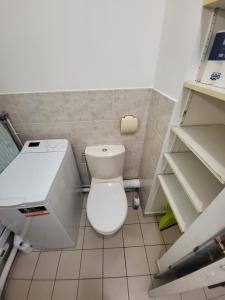 a small bathroom with a toilet and shelves at Charmant studio Porte St Cloud in Boulogne-Billancourt