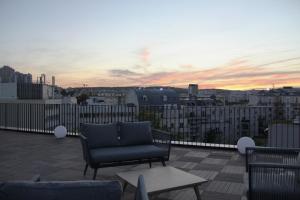 patio con divano e tavolo sul tetto di FINESTATE Coliving Mairie d'Issy a Issy-les-Moulineaux