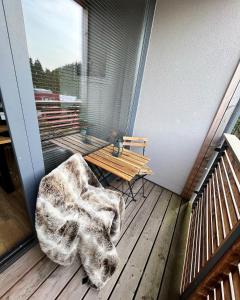 un balcone con panchina e tavolo su una terrazza di U jelena Harrachov - rodinný apartmán u lesa s garáží a Harrachov