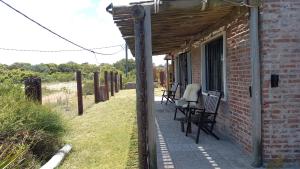 een veranda van een bakstenen huis met stoelen erop bij Agua Corazones in San Luis