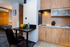 eine kleine Küche mit einem Tisch und einem Waschbecken in der Unterkunft Warsaw Apartments - Apartamenty Sadyba in Warschau