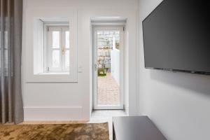 a hallway with a door and a tv and a window at Door 65 - Historical Center Apartments in Porto