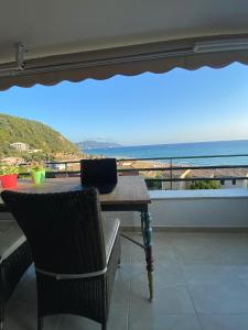 un tavolo e sedie su un balcone con vista sull'oceano di Daydream Seaview Deluxe Home 152 by New Era in Glyfada beach Corfu a Glifada (Glyfada)