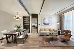 - un salon avec une table et un canapé dans l'établissement Oakwood Residence Foshan, à Foshan