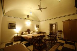 1 dormitorio con 1 cama, mesa y sillas en Khas Bagh, en Jaipur