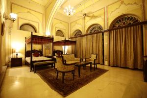 1 dormitorio con 1 cama, mesa y sillas en Khas Bagh, en Jaipur