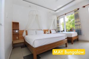 um quarto com 2 camas e uma janela em MAY Bungalow em Mui Ne