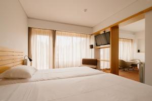 a hotel room with a bed and a television at Parque do Rio Ofir Hotel in Esposende