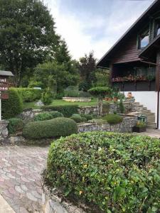 un jardin avec un chemin en pierre et des buissons ainsi qu'un bâtiment dans l'établissement Apartment Monte Rosa, à Delnice